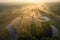 Sunrise over foggy river from above. Bright sunrays on misty river on meadow. Summer nature aerial view