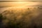 Sunrise over foggy riverbank. Fog on river aerial view. Misty river in sunlight from above