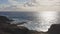 Sunrise over the island of Oahu. White clouds float across the blue sky. Blue Waves of the Pacific Ocean Beats Oahu