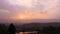 Sunrise over mountains with country side farming fields and orange dramatic sky at dawn at village