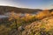 Sunrise over river Litava valley near ruins of Cabrad castle during autumn sunrise with fall coloured trees