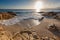 Sunrise over a rocky inlet with gentle surf