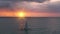 Sunrise over sailboat cruising at ocean slow motion aerial. Nature seascape. People on sailing boat