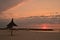 Sunrise over sea beach, reed umbrellas, landscape