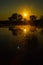 Sunrise over a small farm lake with mist rising off the water.