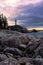 Sunrise over a tall lighthouse situated on a rugged rocky coast - Vancouver Canada