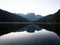 Sunrise panorama mirror reflection view of alpine forest mountain lake Piburger See Oetztal Alps Tyrol Austria Europe