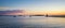 Sunrise panorama of Spring Point Ledge Lighthouse and a harbor