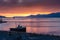 Sunrise in the port of Ushuaia, with a docked ship in the foreground and some ships on the horizon