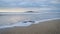 Sunrise at Rangitoto Island, slow movement of sea waves at foreground, Milford beach, Auckland