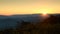 Sunrise with rays spilling over a mountain at Ouachita National forest