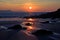 Sunrise reflected in the wet sand and rocks of Freshwater East beach