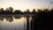 Sunrise on the riverbank. Landscape with reeds on first plan and smoke on the water