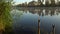 Sunrise on the riverbank. Landscape with reeds and fishing rod stands