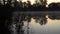 Sunrise on the riverbank. Landscape with silhouettes of reeds in left side and river surface with smoke on the water