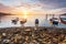 Sunrise rocky shore with fishing boat