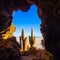 Sunrise on the salt flat of Uyuni inside a cave with cactus in front, Bolivia