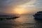 Sunrise on the sea. Wooden piles of destroyed pier sticking out of the water and boat. Morning sun rays. Red sea, Egypt