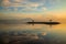 Sunrise seascape. Mountains and Agung volcano. Traditional gazebos on an artificial island in the ocean. Water reflection. Sanur