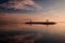 Sunrise seascape. Mountains and Agung volcano. Traditional gazebos on an artificial island in the ocean. Water reflection. Sanur