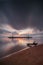 Sunrise seascape. Traditional gazebos on an artificial island in the ocean. Long chair on the beach. Water reflection. Calm water