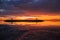 Sunrise seascape. Traditional gazebos on an artificial island in the ocean. Water reflection. Bright sunlight at horizon. Couldy