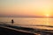 Sunrise silhouette of a man in Kamari beach, Greece