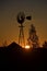 Sunrise silhouette of wind mill and barn