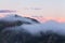 Sunrise. Spring scenery in foggy day. Panoramic view in lawn are covered by pink rhododendron flowers. Beautiful photo of mountain