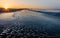 Sunrise starburst at Cape May, NJ, beach as low tide flows across the sand