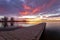 Sunrise or sunset on the fishing dock with colorful clouds reflecting in the lake