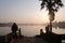 Sunrise , sunset over lake in angkor wat with sun reflecting in the water and palm and snake statue in foreground