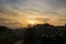 Sunrise or sunset over the town, beautiful colorful clouds over the buildings, roofs and chimney.