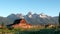 sunrise view of grand teton and a mormon row barn