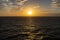 Sunrise view over seascape with water waves reflecting sunlight