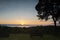 Sunrise viewpoint with silhouette of tree on mountain