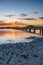 Sunrise waterscape with wharf, boats and clouds