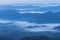 Sunrise white fog in early morning over high angle view of layer tropical mountains