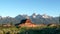 a sunrise wide panning shot of a mormon row barn and grand teton mountain in grand teton national park