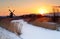 Sunrise by windmill in winter