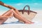 Sunscreen beach woman putting sunblock oil on legs