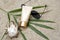 Sunscreen, glasses, shell, palm leaf on sand