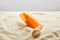 Sunscreen in orange bottle in sand