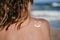 Sunscreen sun drawing lotion on suntan back relaxing tanning at the beach. Woman sitting and relaxing with a smiling shape face