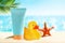 Sunscreen tube mockup for kids and babies with toy duckling on sandy beach and sea background