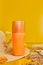 Sunscreen tube mockup with shells, sand yellow background