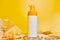 Sunscreen tube mockup with shells, sand yellow background