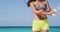 Sunscreen woman. Girl putting sun block on beach holding white sun tan lotion bottle. Beautiful young woman enjoying
