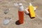 Sunscreens in colourful unbranded bottles on sand