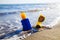 Sunscreens with sunglasses on clear sea sand on sea background. Summer vacation